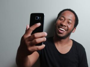 A smiling man holding a phone